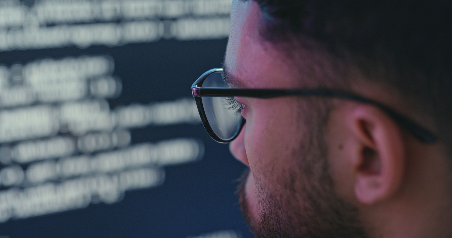 Computer, code and programming with the face of a man programmer working on a mainframe or database. Coder, technology and server with a male it support professional at work in a data center